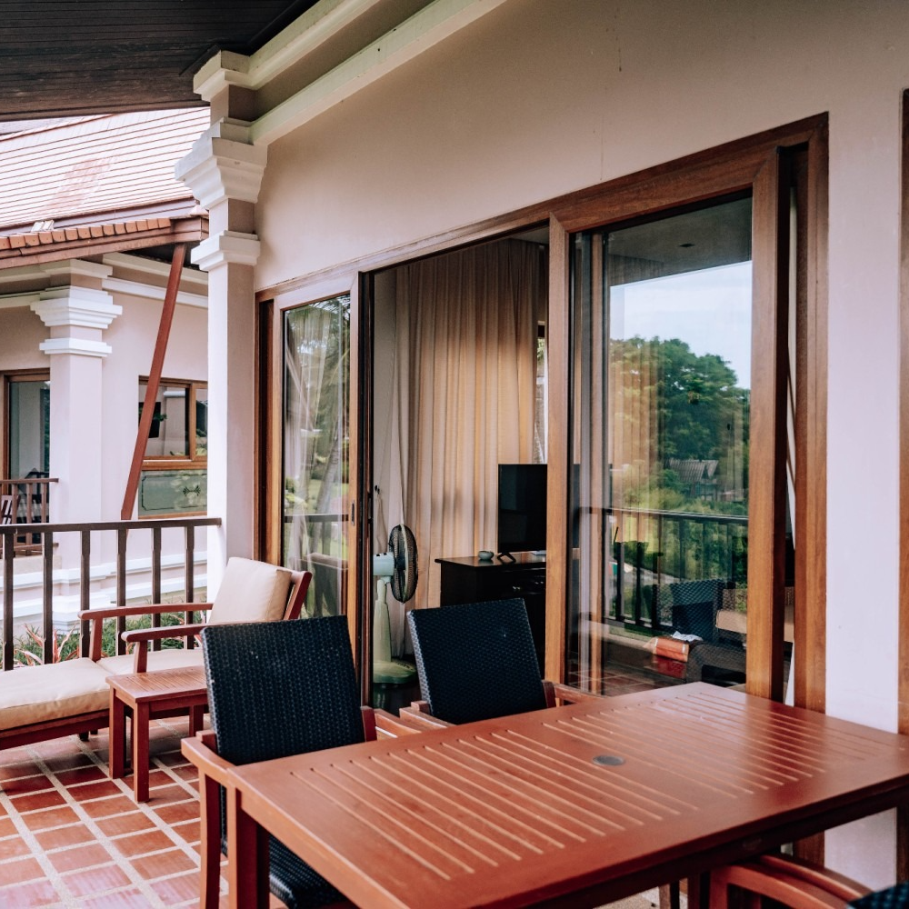 A table and chairs on a balcony with sliding glass doors