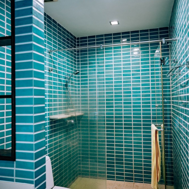 A bathroom with blue tiles and a walk in shower