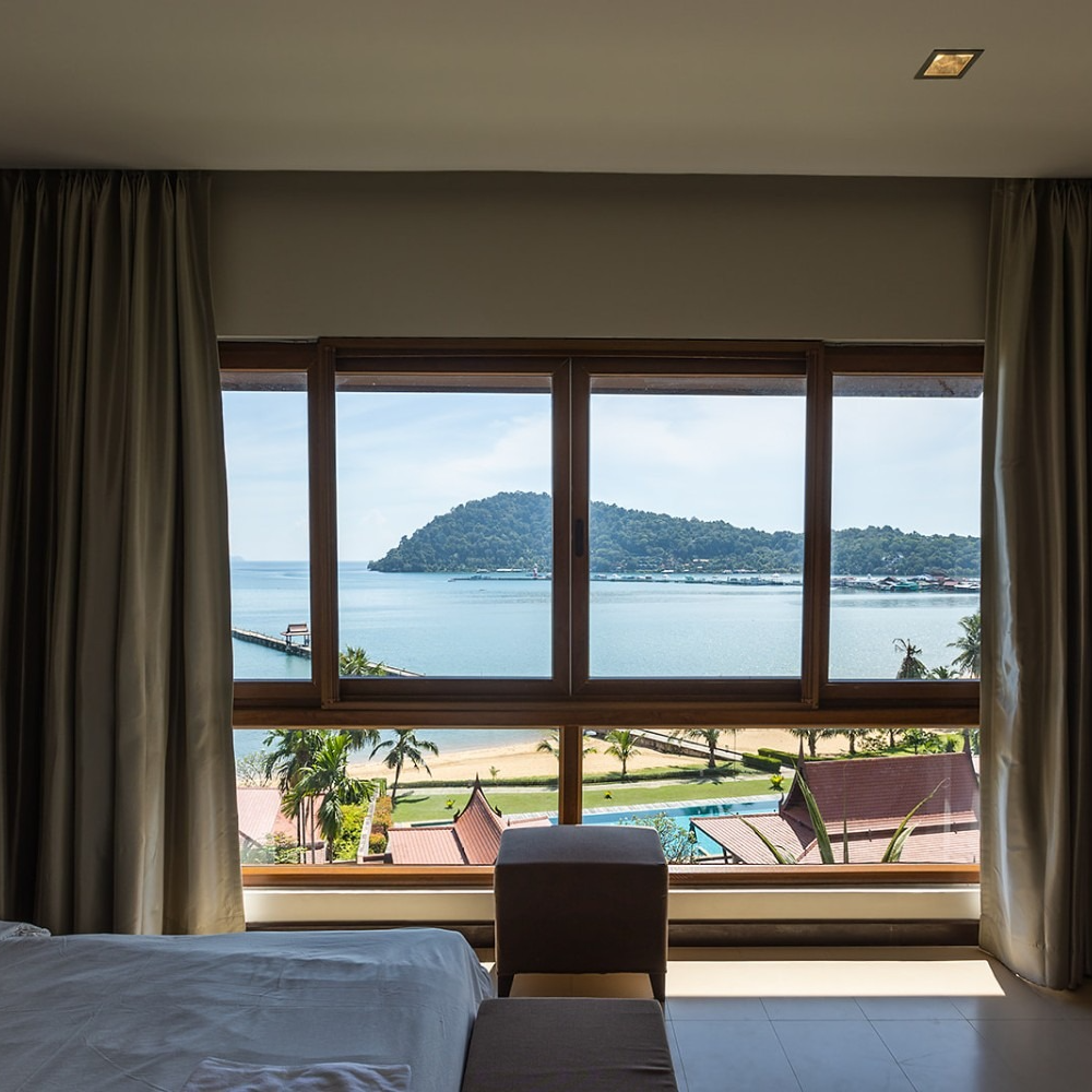 A bedroom with a view of the ocean and mountains