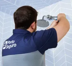 Um homem está consertando um chuveiro com uma chave inglesa.