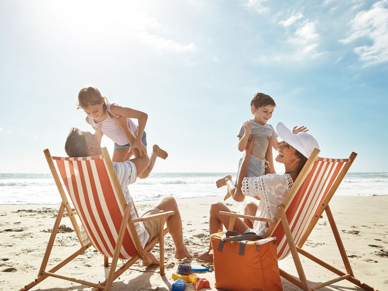 Uma família está sentada em cadeiras de praia na praia.