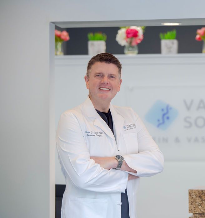 A man in a lab coat is standing with his arms crossed