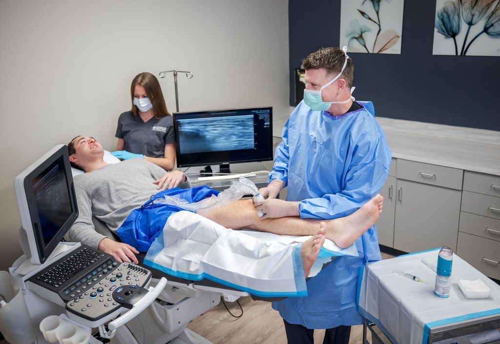 A man is getting an ultrasound on his leg in a hospital.