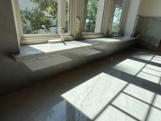 Marble windowsill and floor with sunlight streaming through a window.