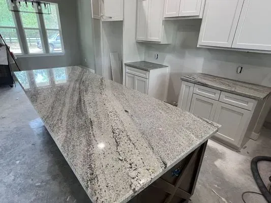 Kitchen with white cabinets, light countertops, and a large island.