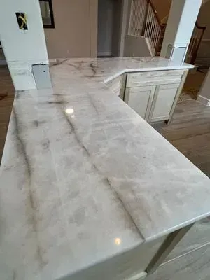 White and gray marbled countertop on a kitchen island.