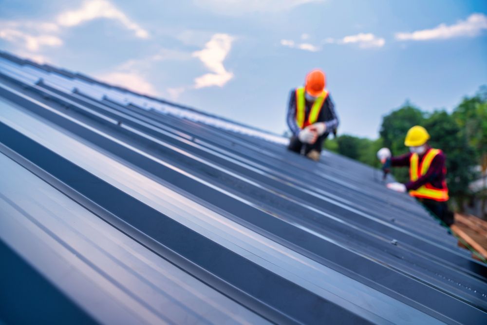 A Person is Using a Drill to Drill a Hole in a Metal Roof — Premier Building QLD In Speewah, QLD