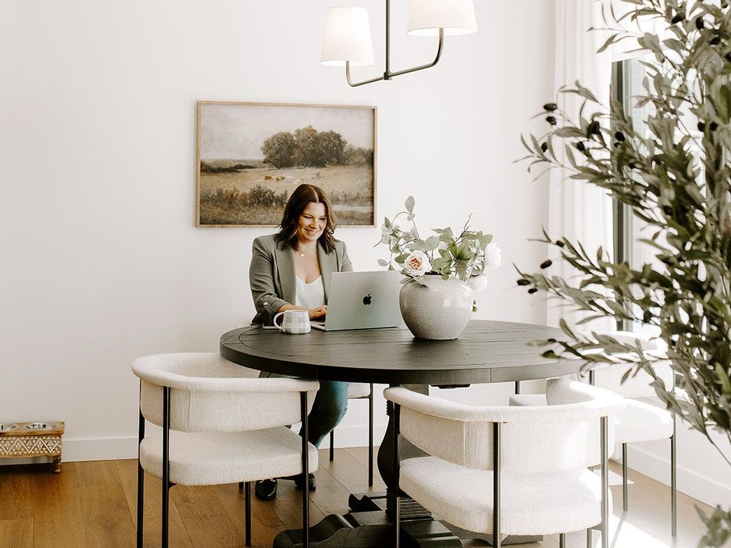 Megan Atamanik is sitting at a table using a laptop computer.