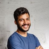 photo of male smiling against gray wall