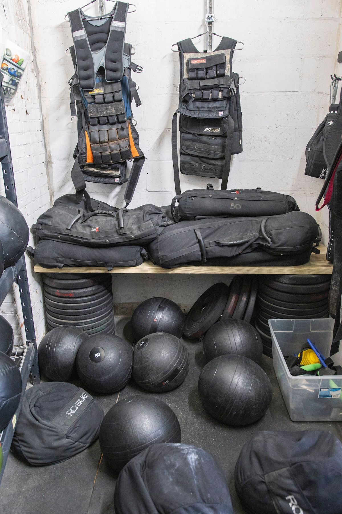 A room filled with lots of black balls and bags.
