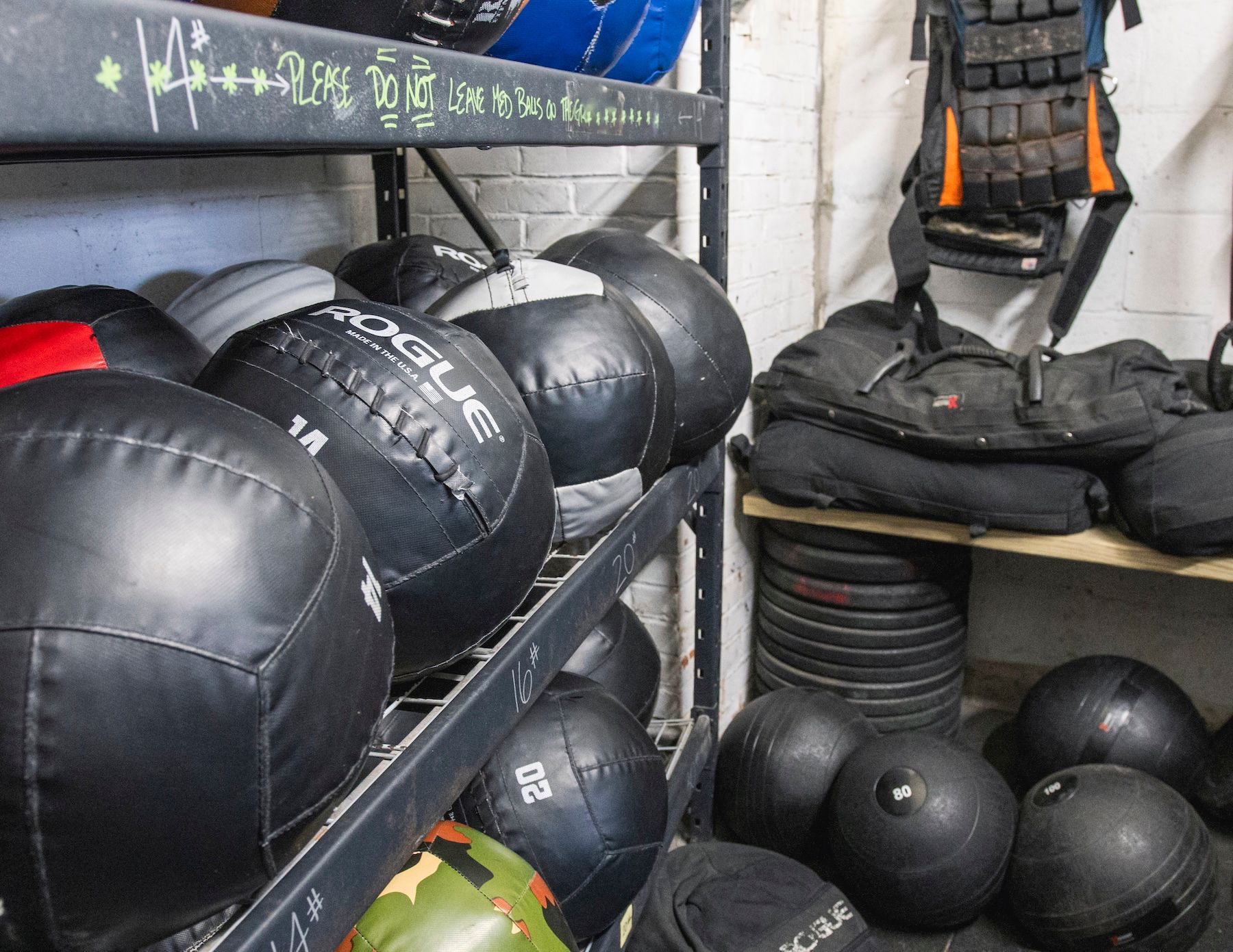 A bunch of rogue medicine balls are on a shelf