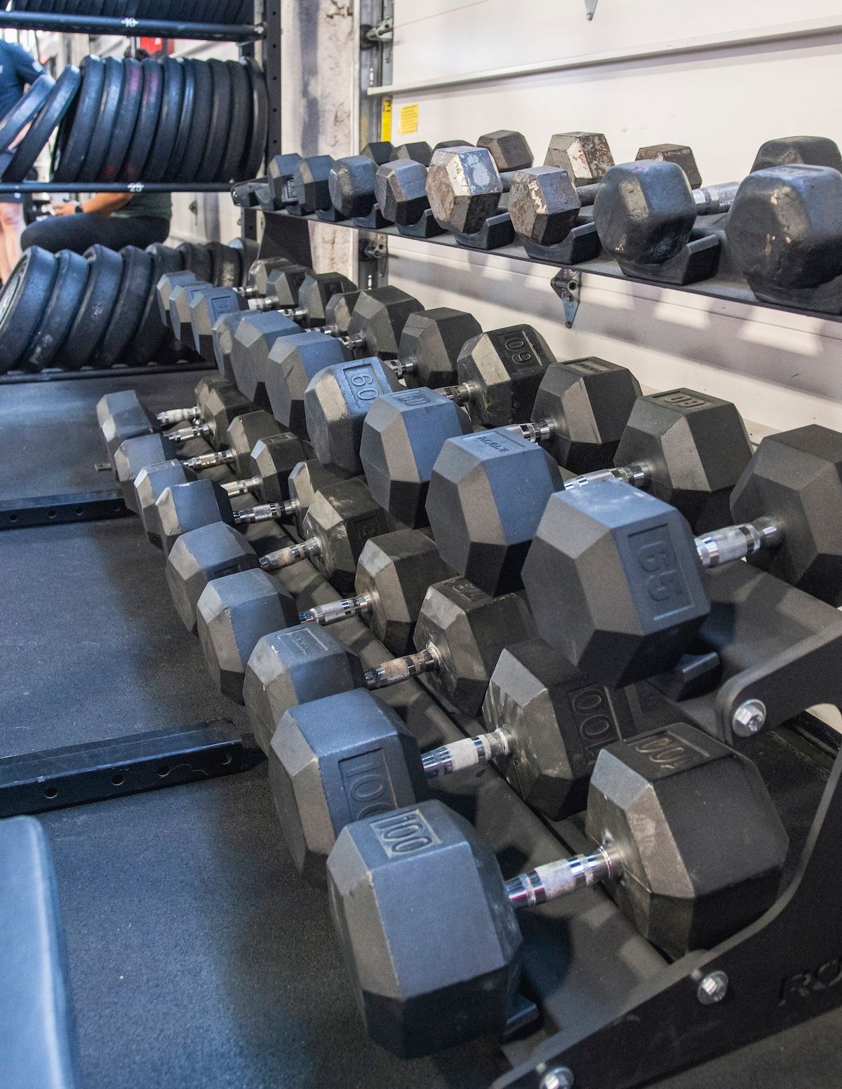 A row of dumbbells are lined up in a gym