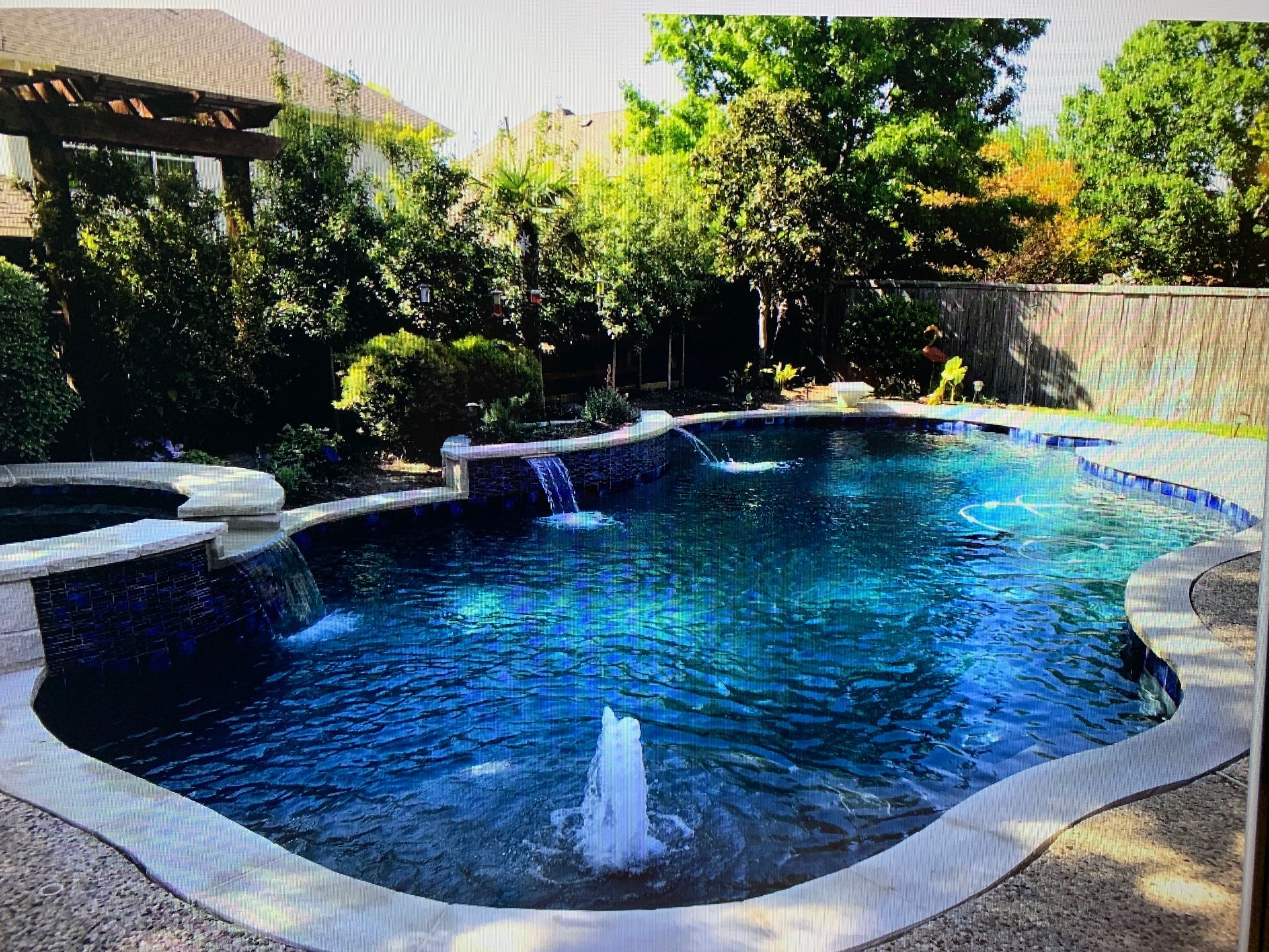A large swimming pool with a fountain in the middle