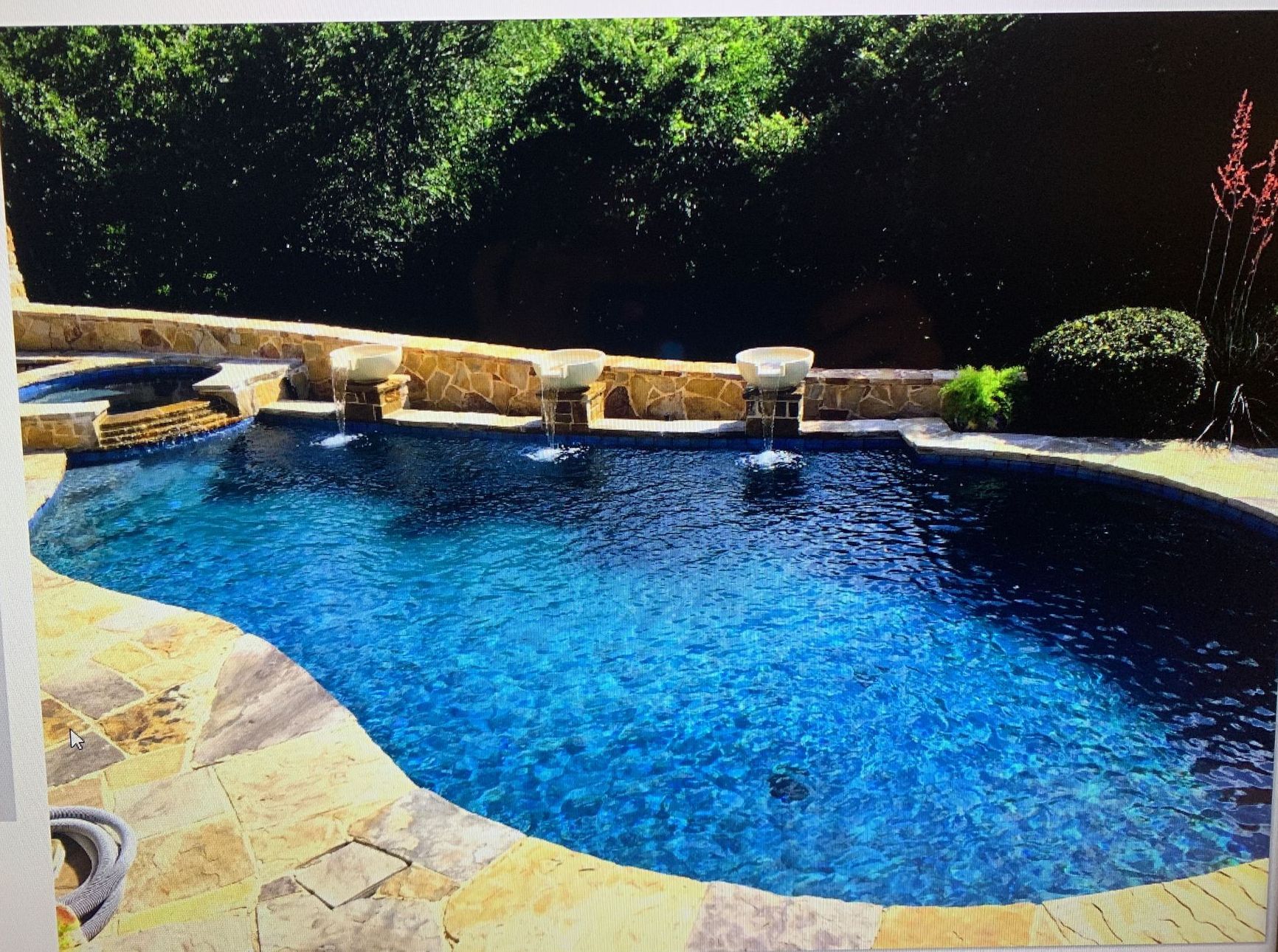 A large swimming pool with a fountain in the middle
