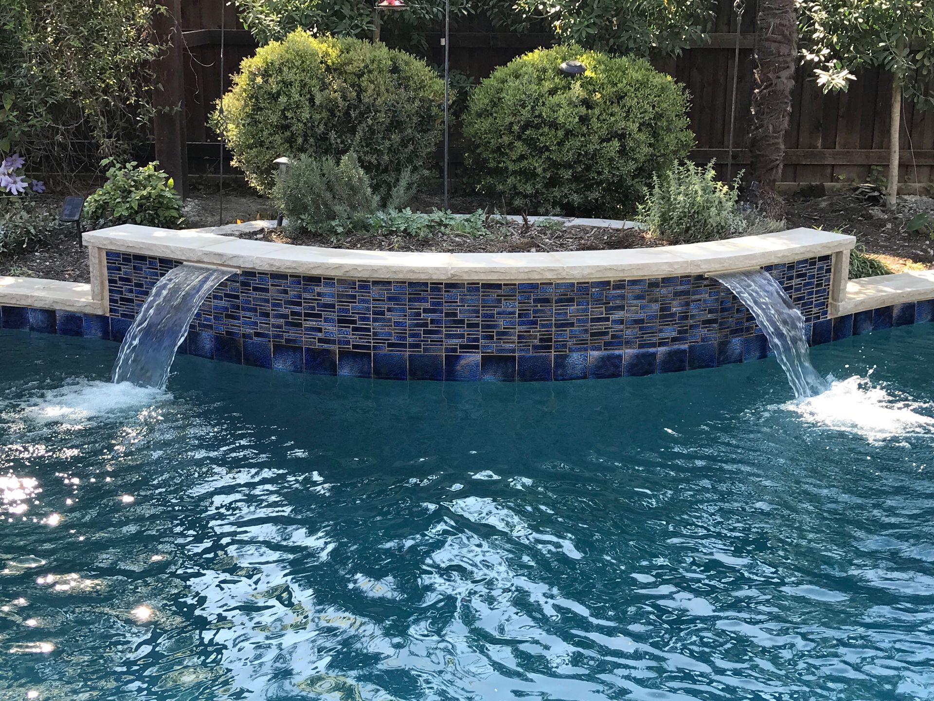 There is a waterfall in the middle of the pool.