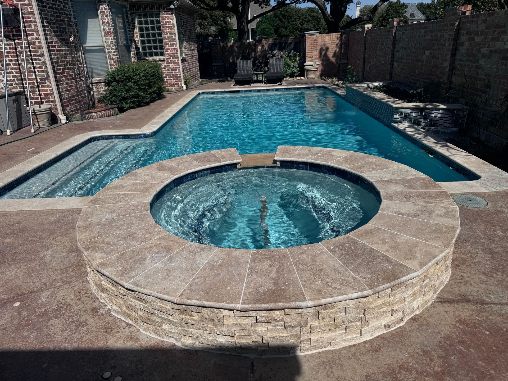 A large swimming pool with a hot tub in the middle
