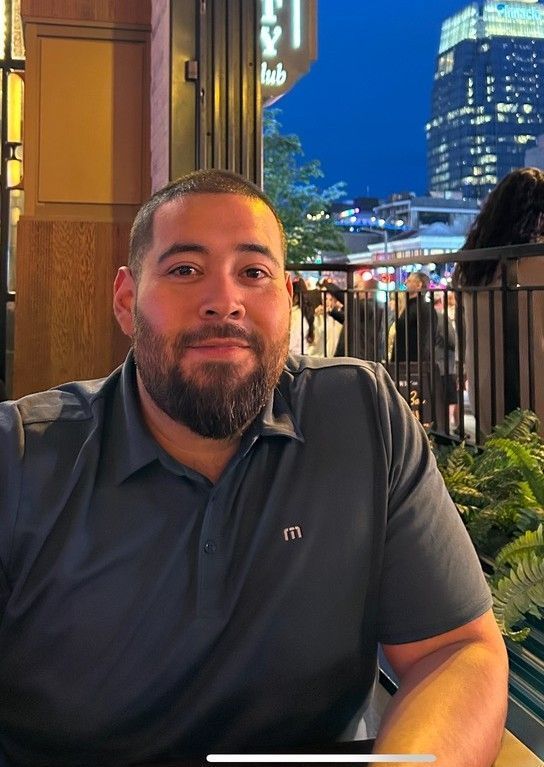A man with a beard is wearing a grey shirt