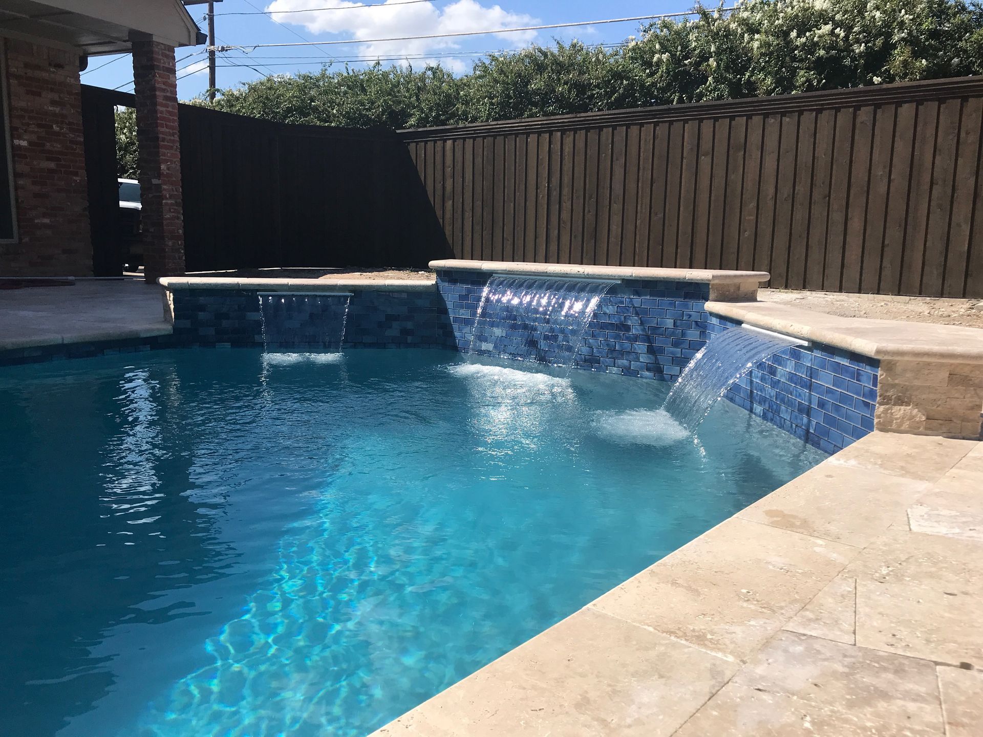 A swimming pool with a waterfall in the middle of it