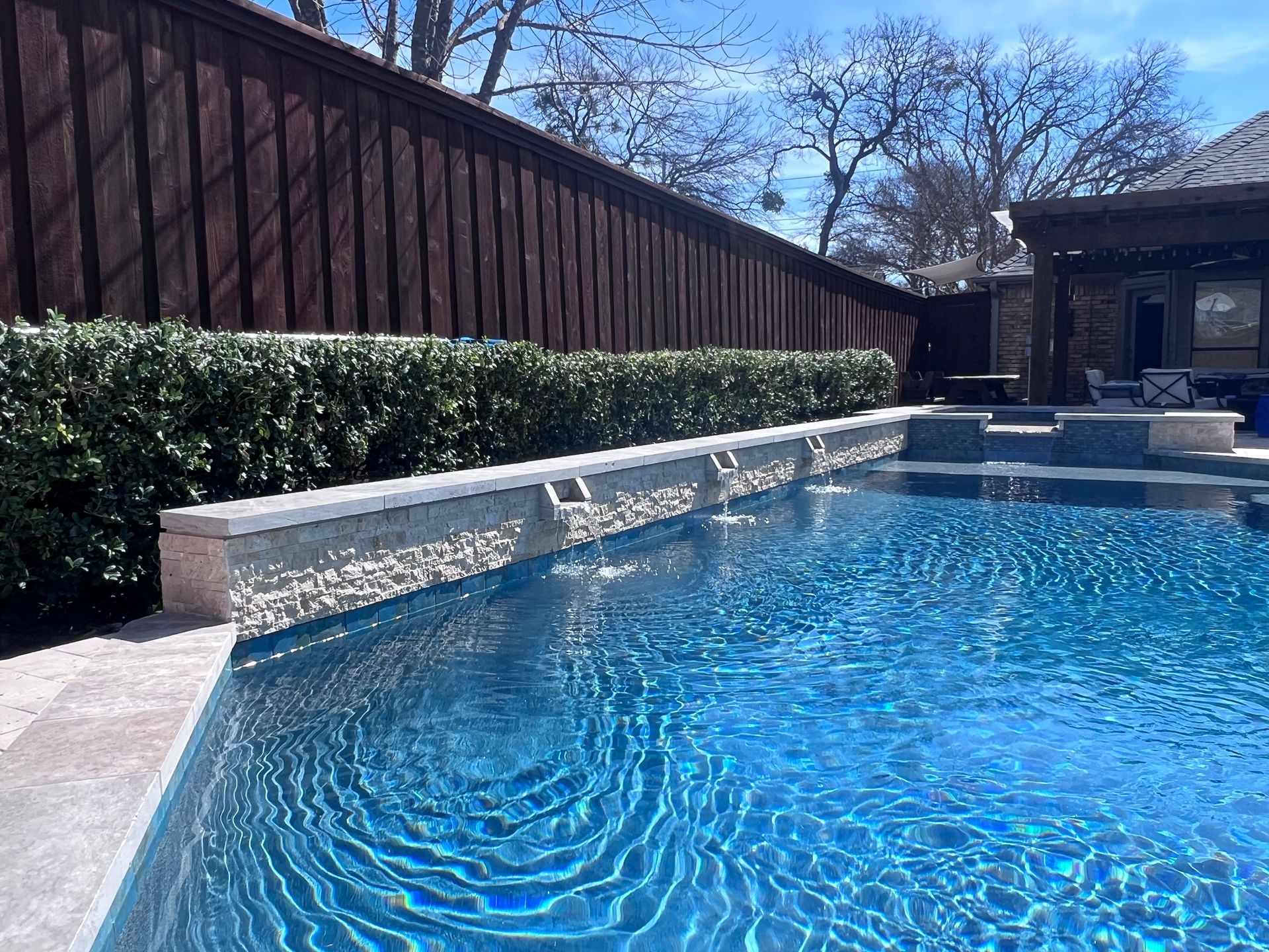 A large swimming pool with a wooden fence surrounding it.