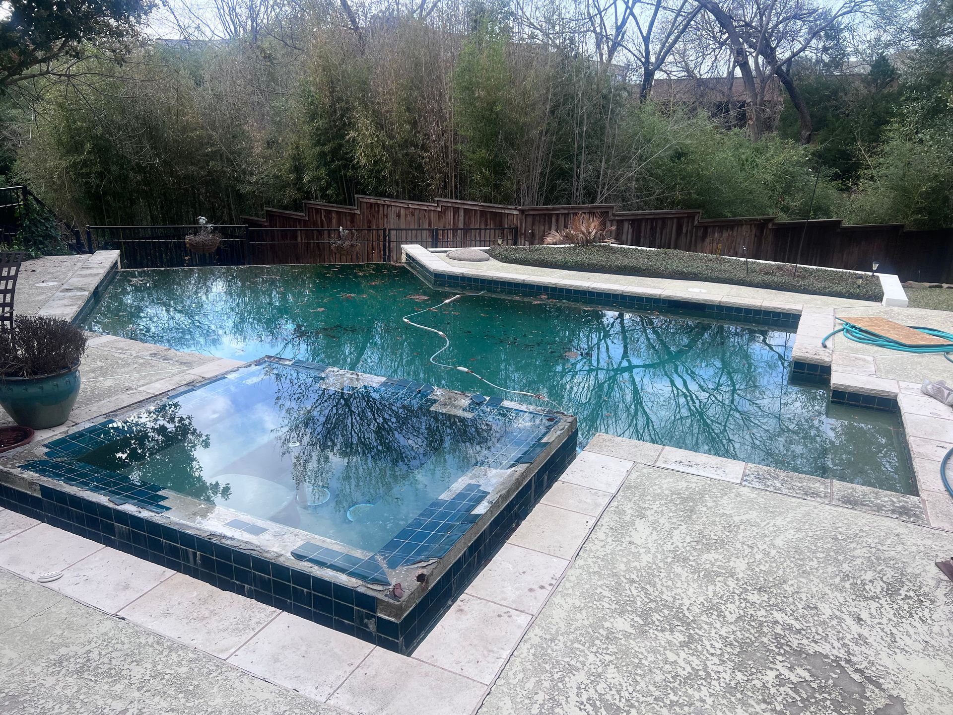 A large swimming pool with a hot tub in the middle of it.