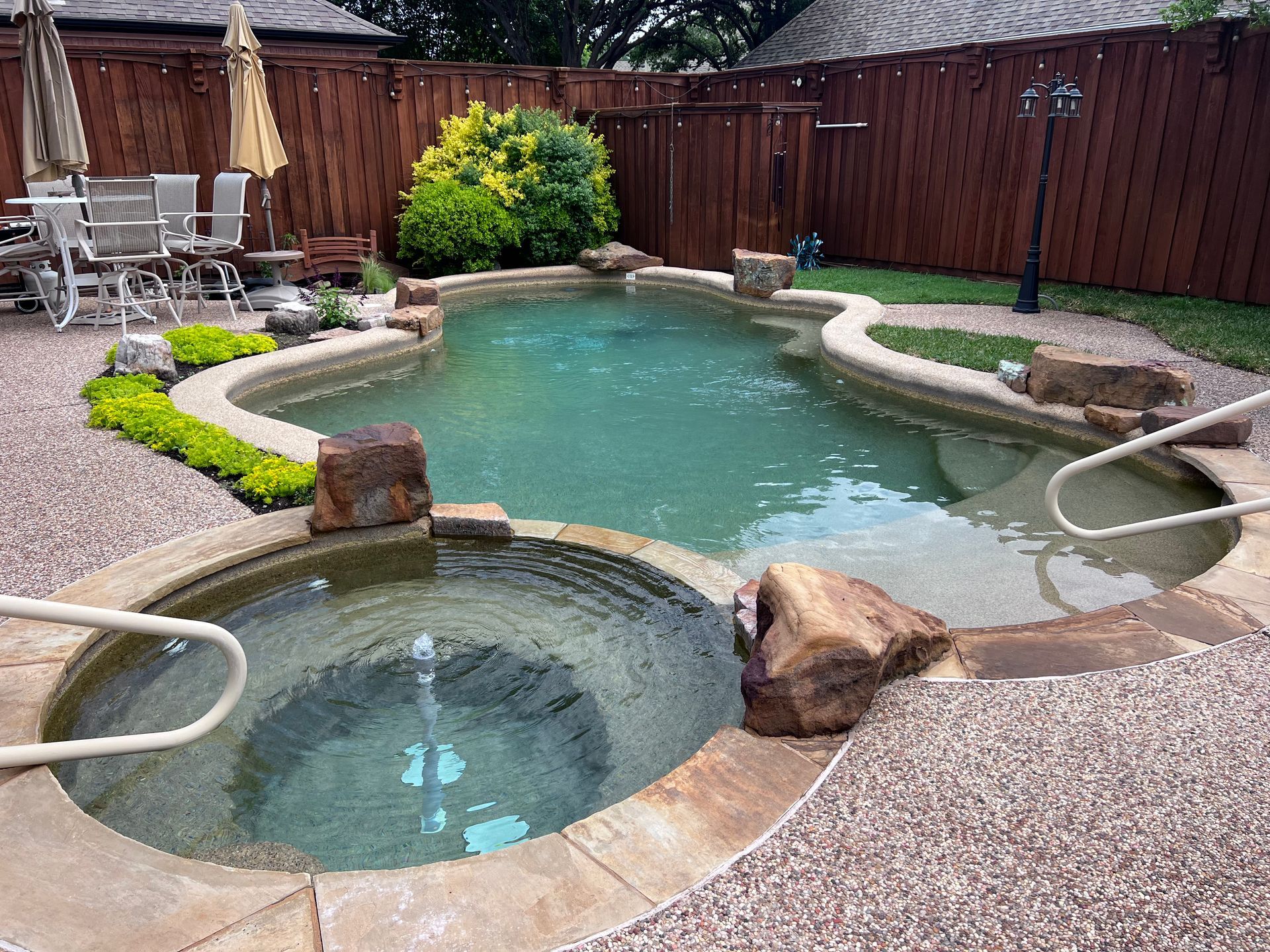 A large swimming pool with a hot tub in the middle of it.