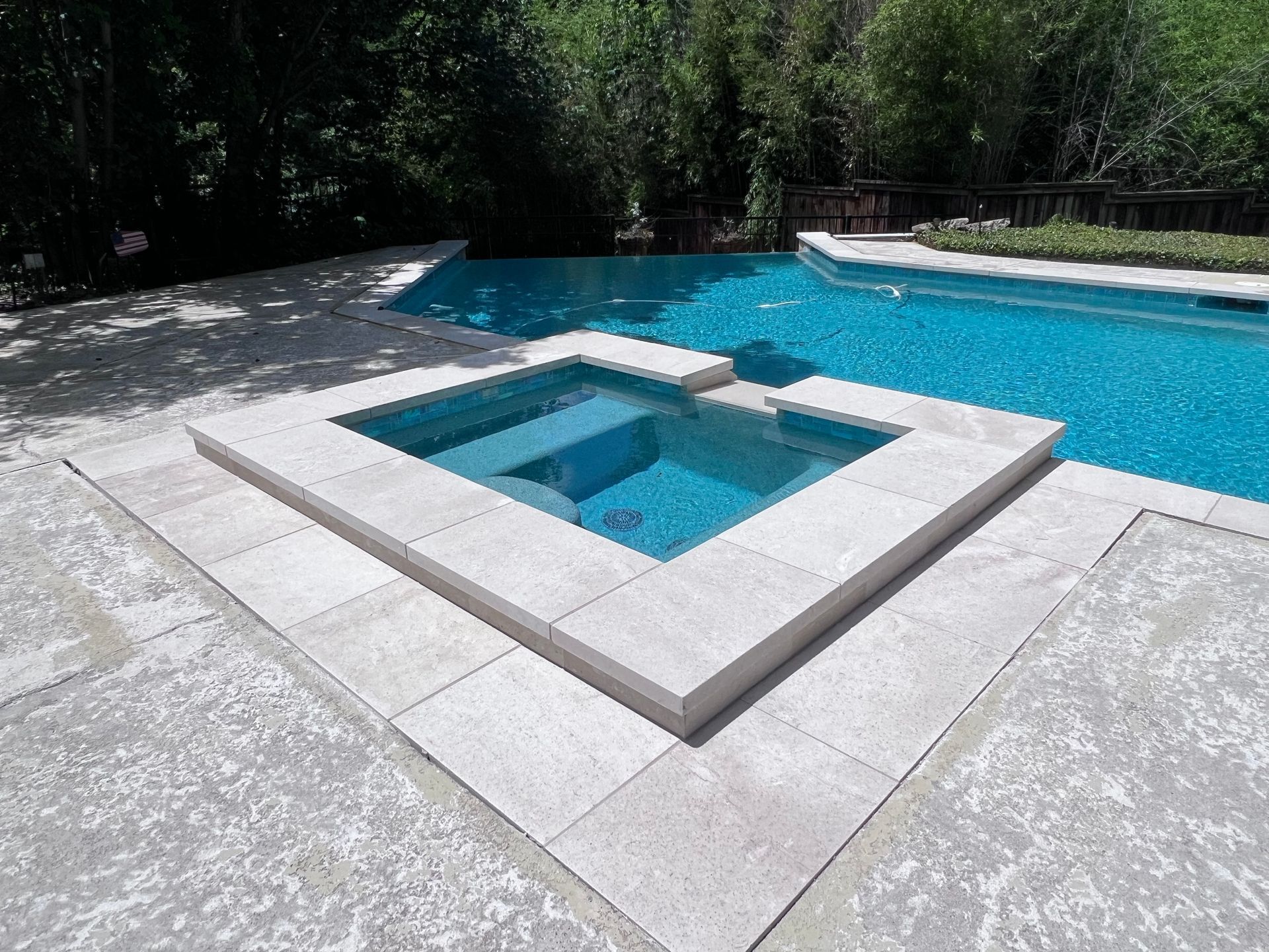 A swimming pool with a hot tub in the middle of it