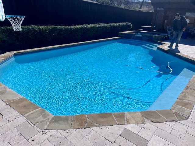 A large swimming pool with a basketball hoop in the background