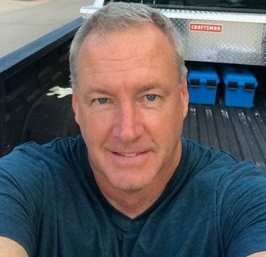 A man is taking a selfie in the back of a truck.