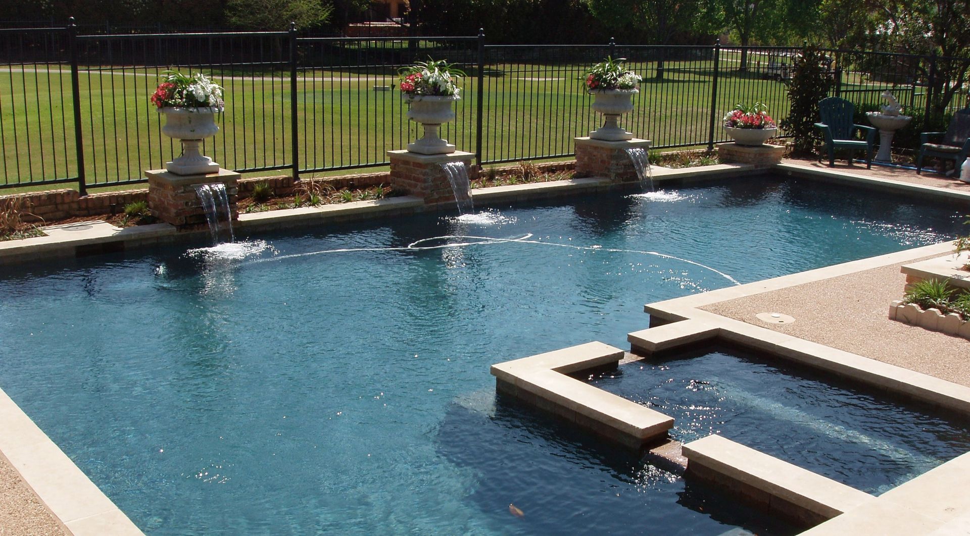 A large swimming pool with a hot tub in the middle