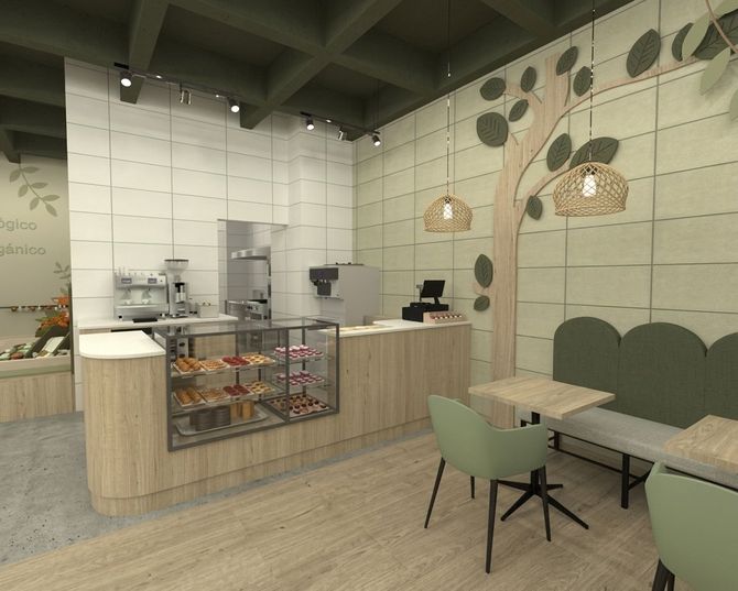 Interior de cafetería moderna con mostrador, vitrina de pasteles, mesas y decoración de pared verde.