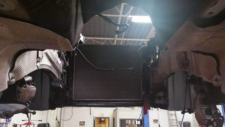 Dim workshop with two suspended vehicles or equipment pieces under bright ceiling lights