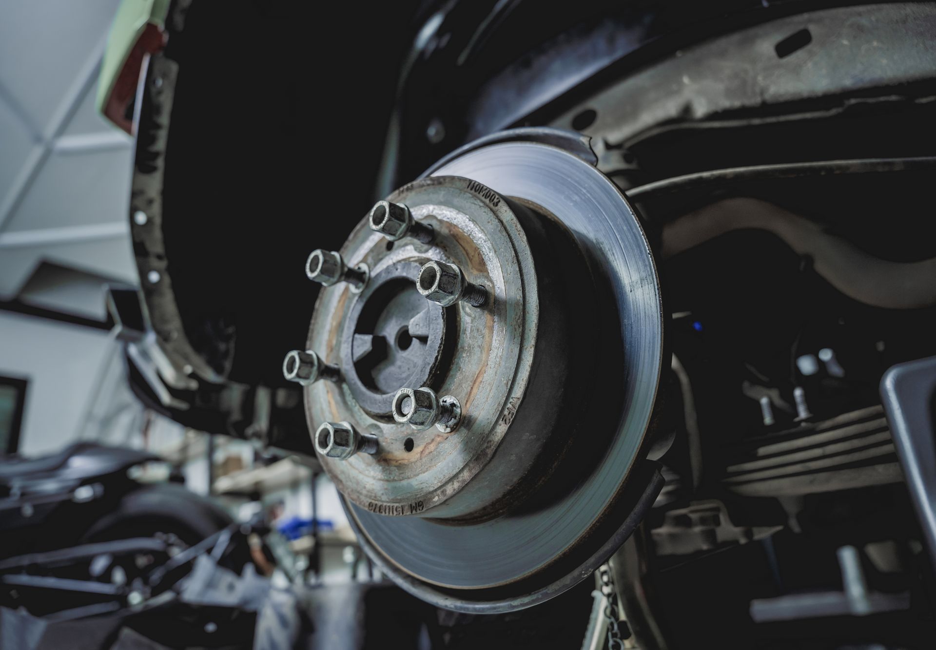 Car wheel and brake rotor exposed during repair in a garage