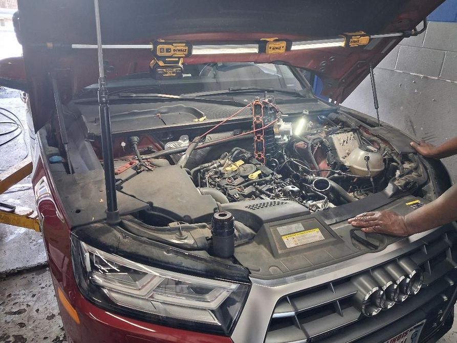 Mechanic working on a car battery in an engine bay