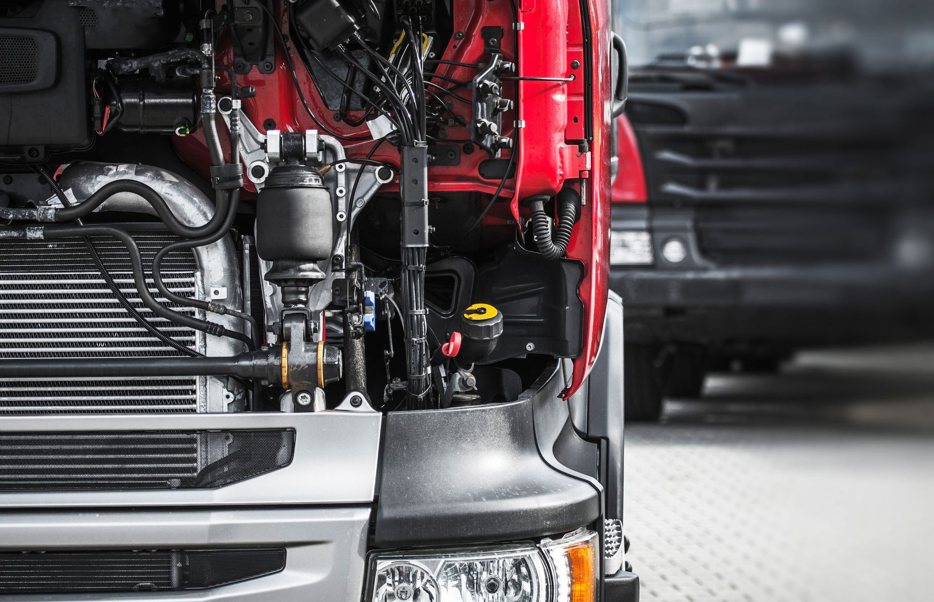 Semi-truck engine bay with hood open, exposing mechanical components and engine.