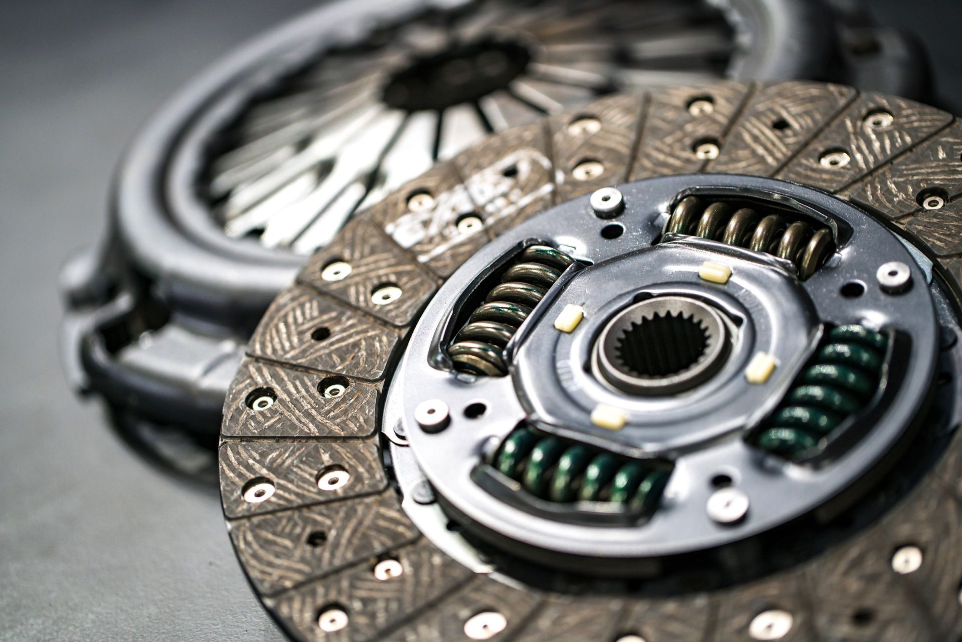 Car clutch assembly, detailed view. Includes pressure plate, clutch disc, and flywheel.