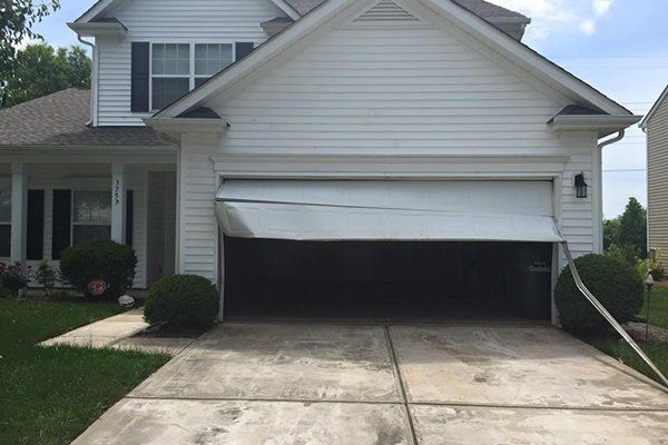 Suburban house with a two-car garage, driveway, and front lawn in daylight