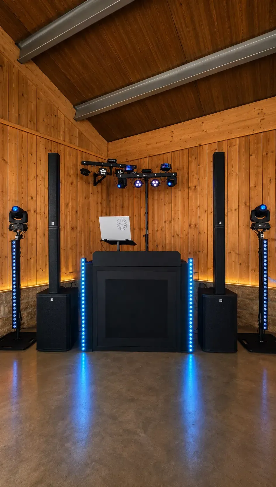 Symmetrisches DJ-Setup mit Lichttechnik in einer Holzscheune