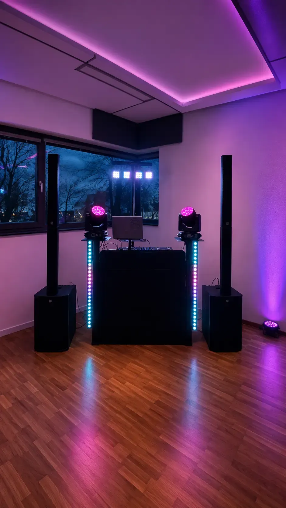 DJ-Setup mit Säulenlautsprechern und pinker Raumbeleuchtung
