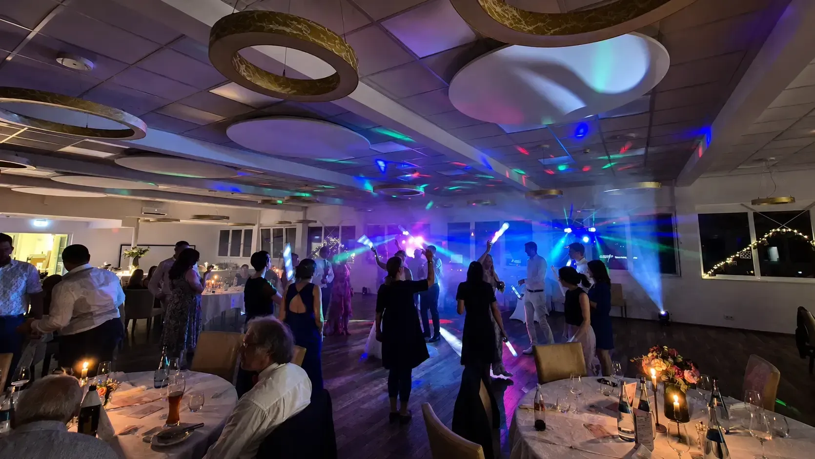 Hochzeitsfeier mit tanzenden Gästen und farbiger Lichtshow