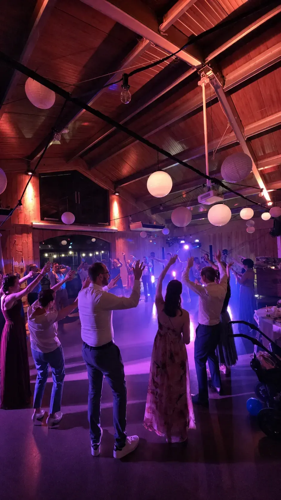 Feiernde Gäste mit erhobenen Händen auf einer Hochzeit
