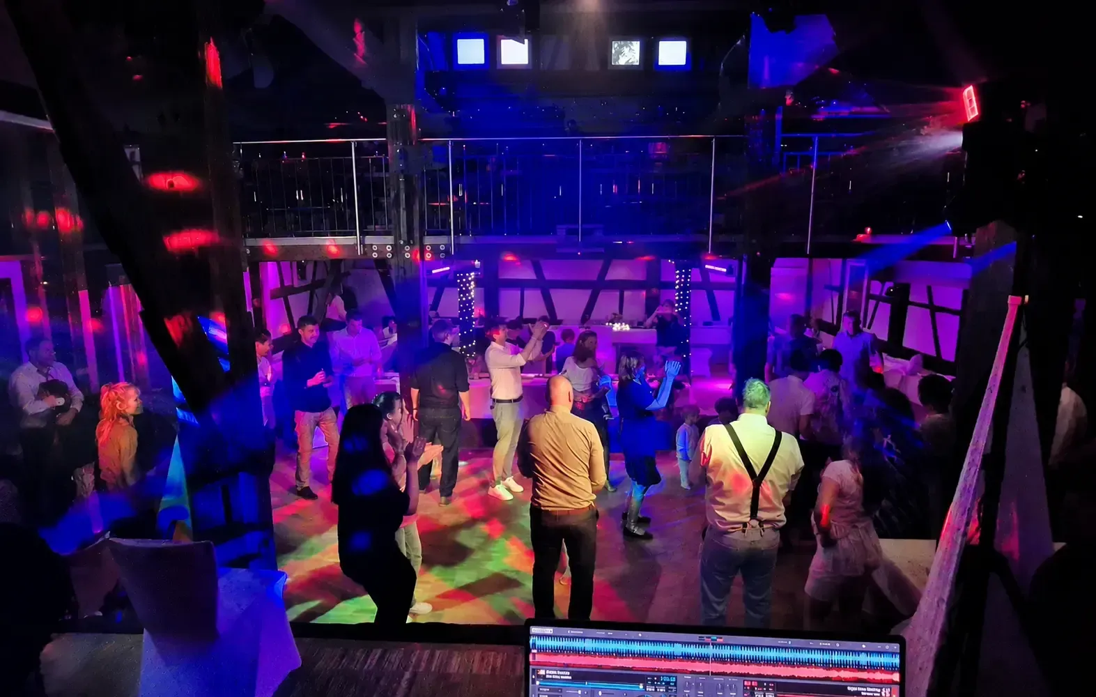 Blick vom DJ-Pult auf eine beleuchtete Tanzfläche