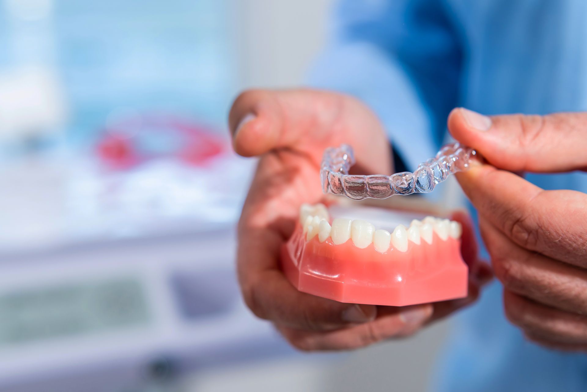 Clear dental aligner on a glossy blue surface, lit in cool tones