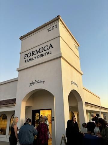 FORMICA Family Dental building entrance at dusk, with people gathered outside
