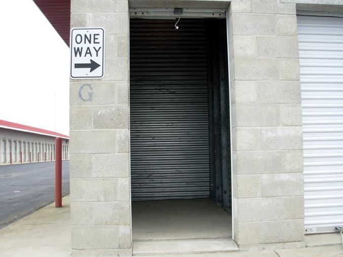 A one way sign is on the side of a building