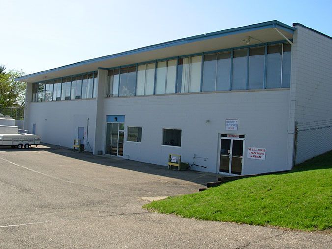 A large white building with a blue roof and a lot of windows