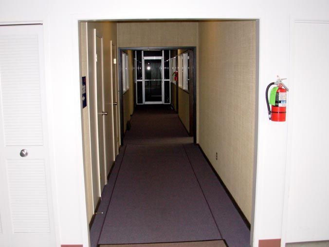 A long hallway with a fire extinguisher on the wall