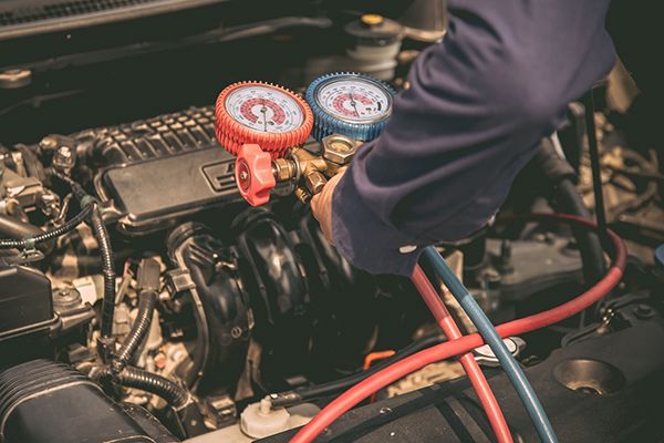 A man is working on the engine of a car.