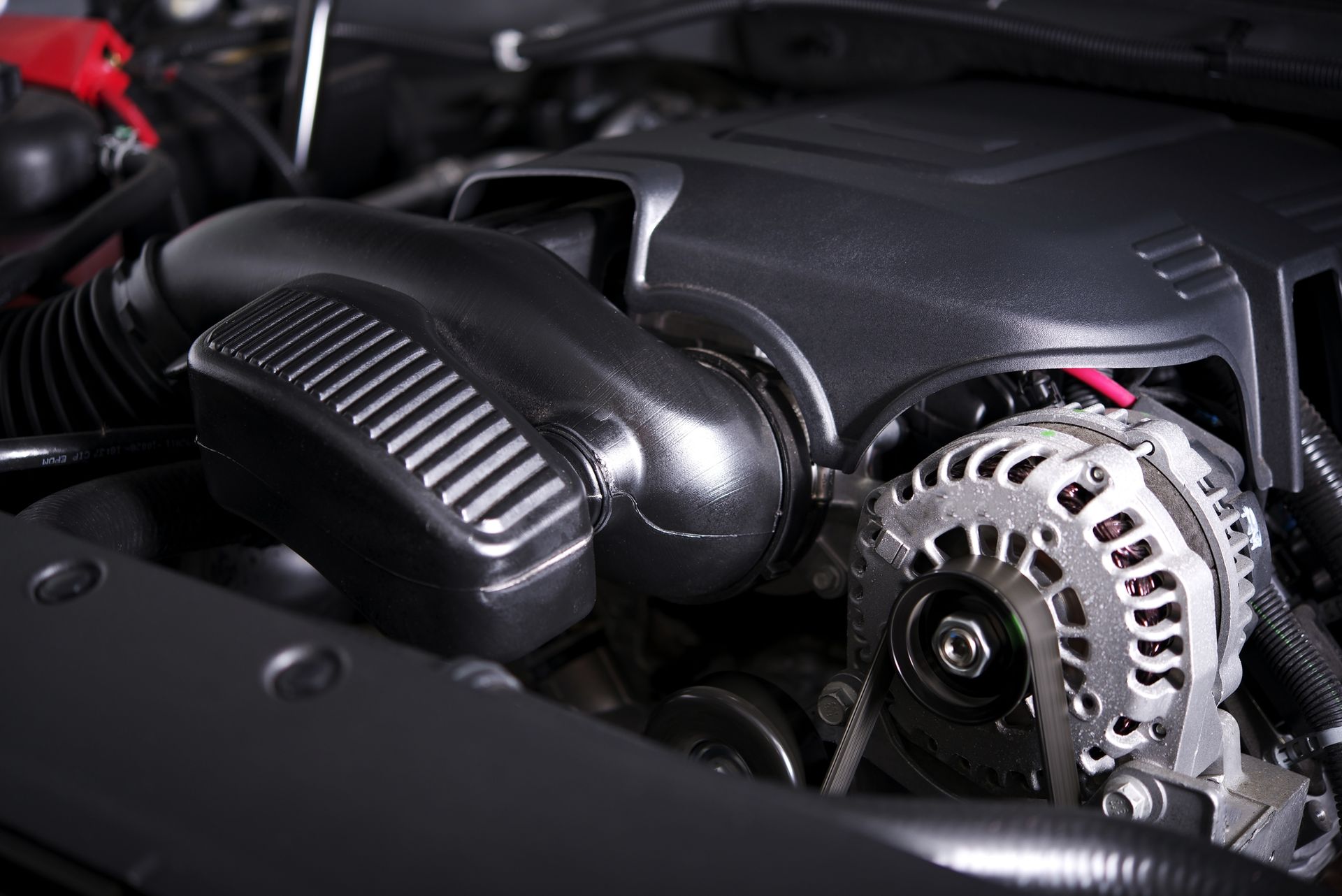 A close up of a car engine with the hood open