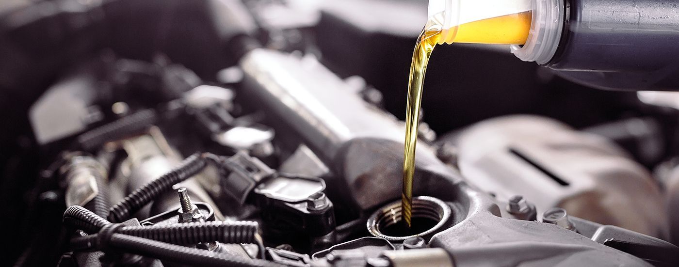 Motor oil pouring into a car engine.