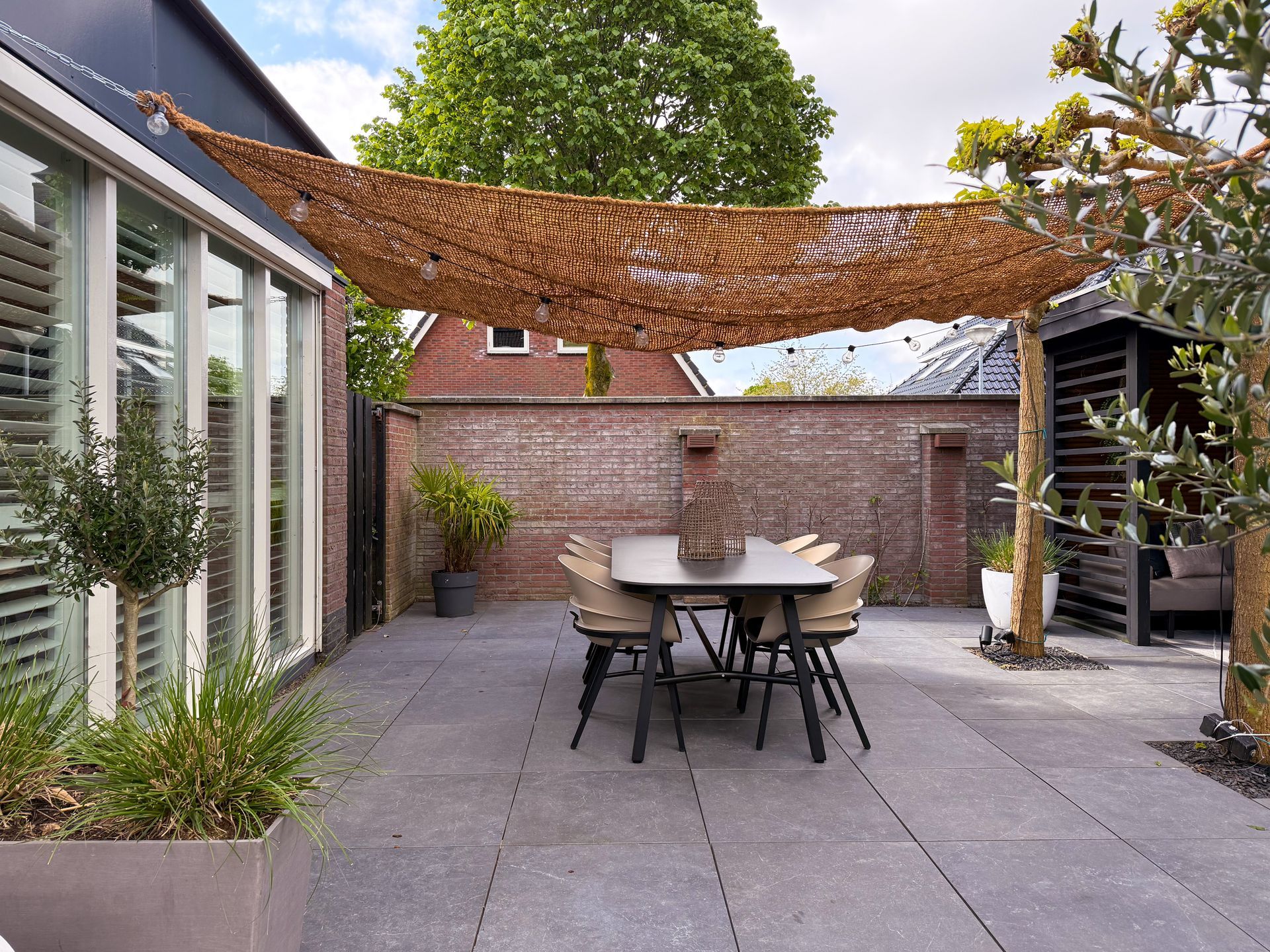Kale rode bakstenen tuinmuur voor renovatie met mediterraanse steenstrips. 